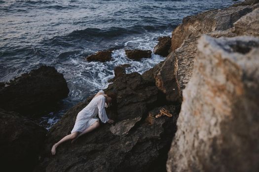 Beautiful bride in a secluded spot on a wild rocky coast in a white dress nature. High quality photo