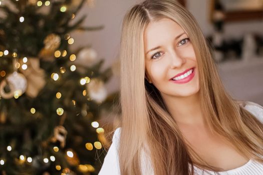 Christmas time and holiday mood concept. Happy smiling woman and decorated xmas tree lights on background.