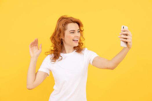 selfie woman. Image of excited happy young woman isolated overyellow background make selfie by camera. cool cheerful redhead girl selfie