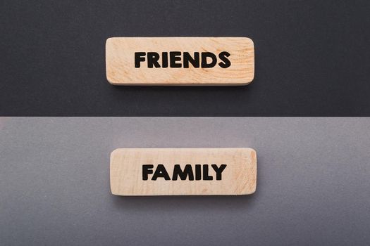 Hand writing word friend and family text on wooden board. Life balance chart