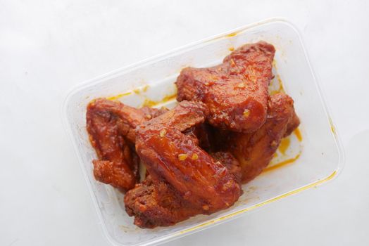 chicken wings in a plastic take away container .