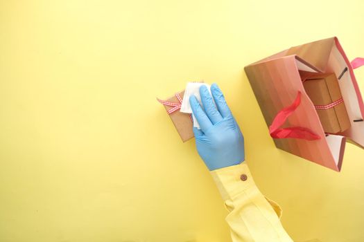 hand in latex gloves wapping a gift box with tissue .