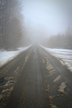 Bad weather driving - foggy hazy country road. Motorway - road traffic. Winter time and snow.
