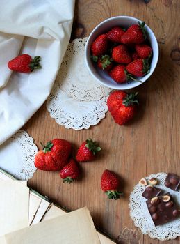 Red strawberries and chocolate in beautiful style. Wooden background. Vintage closeup. Natural background. Sweet food. Design wallpaper for your desktop or calendar.