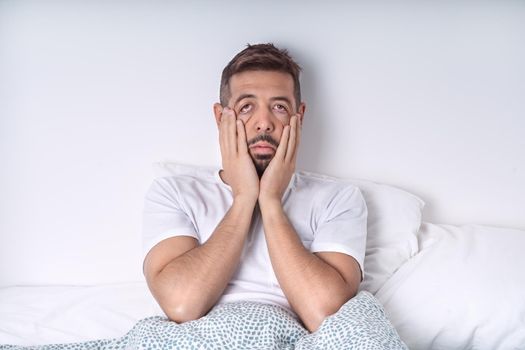 Stressed and depressed man lying in the bed. Bad mood and bad morning. High quality photo