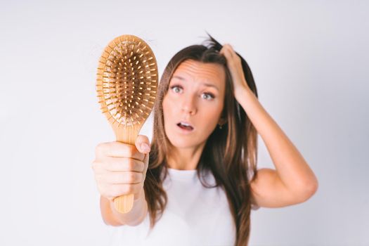 Woman with hair brush with damaged hair. Hair loss problem. Hair falling out. High quality photo