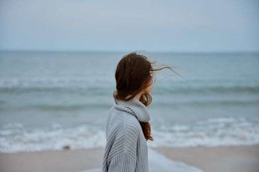 woman red hair in a sweater by the ocean unaltered. High quality photo