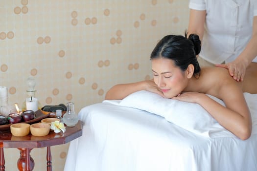 Asian beautiful girl close her eyes and lie on bed and enjoy the spa massage in the room with day light.