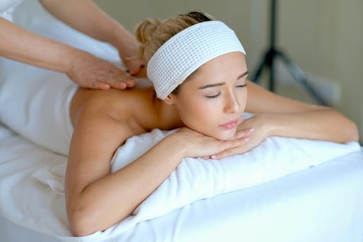 Young beautiful woman enjoy with massage in spa room with day light and she look relax and happy.