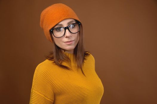 Attractive middle-aged Caucasian woman wearing a yellow sweater hat and glasses looks at camera. Vision problem and people wearing glasses.