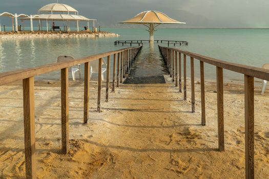 Fenced off with a wooden railing, the entrance leading to the canopy into the water of the Dead Sea