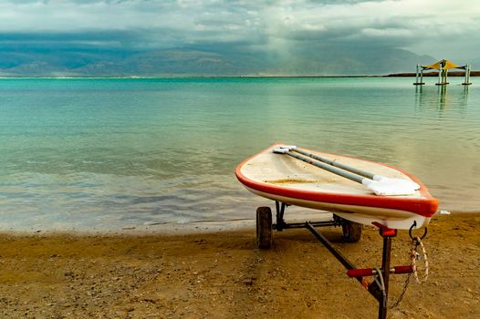 A lifeguard boat stands on wheels on the shore of a deserted beach