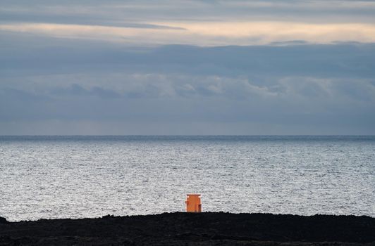 Tiny lighthouse facing the huge ocean