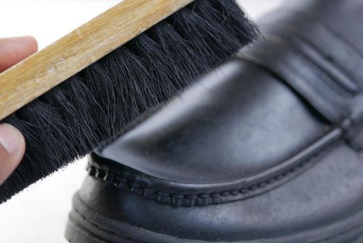 cleaning Shoe with a brush on floor .