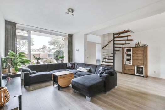 The living room interior in bright colors, gray sofa over a light parquet floor