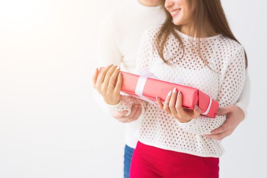 People, christmas, birthday, holidays and valentine's day concept - happy young man and woman with gift boxes on white background with copy space.