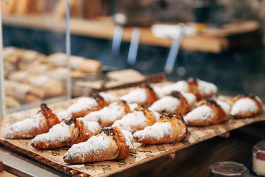 Croissants with sugar sprinkles lie on the showcase of a pastry shop. High quality photo
