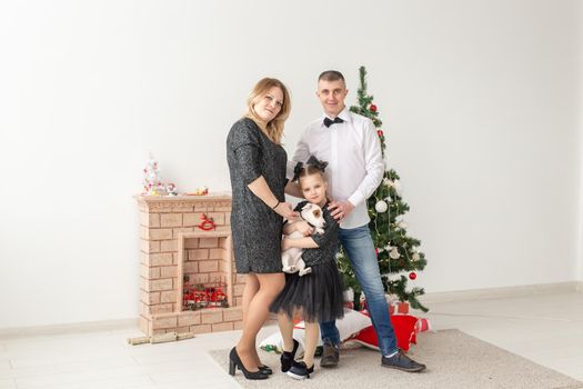 Holidays concept - happy family mother father and child at christmas tree at home.