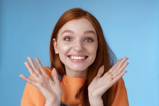 Happy rejoicing emotional young smiling redhead girl blue eyes getting exciting news grinning cheering happily raise hands thrilled wide eyes surprised accepted famous university, blue background.