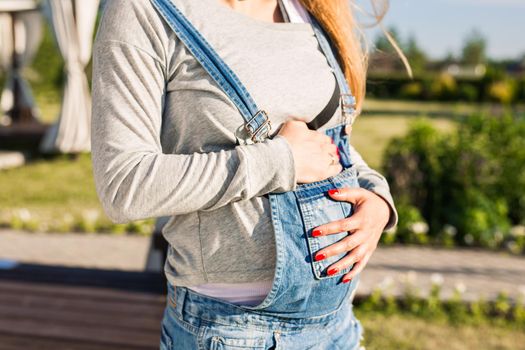 Close up of a cute pregnant belly outdoors