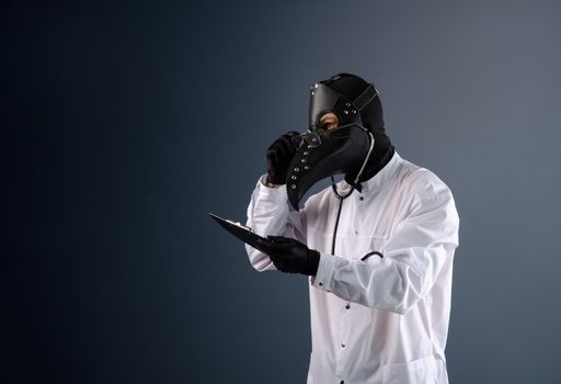 doctor in a dressing gown wearing a plague doctor mask with a stethoscope in his hands