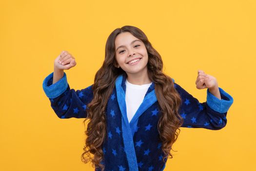 in good mood. sleepy kid stretching sleepily. smiling child wearing comfortable pajama or home bathrobe. good morning. sweet dreams. feeling cozy and relaxed. happy teen girl just woke up.