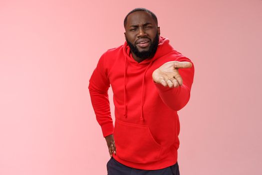 Displeased african-american man scolding friend acting bad asking what doing life pointing camera palm arguing standing disappointed judging mate outfit, standing pink background. Copy space