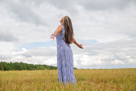 beautiful woman dance in summer field. feeling of freedom and happiness