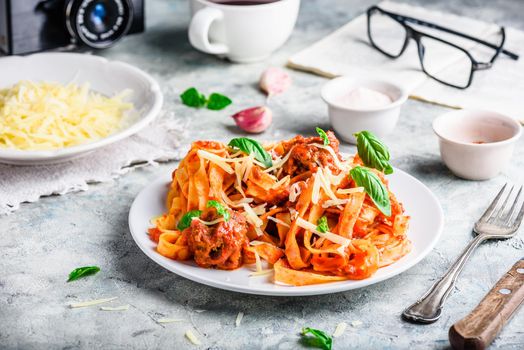 Pasta with mini meatballs, tomato sauce and parmesan cheese