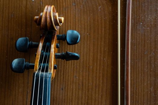 Part of a violin on a brown background. Violin handle. Place for text.