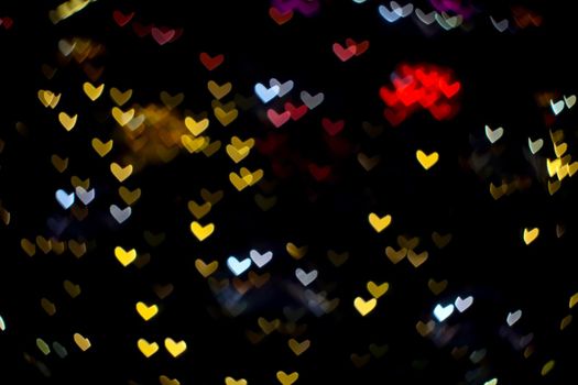 colorful abstract bokeh and blur heart shape love valentine night light on wall at shopping mall