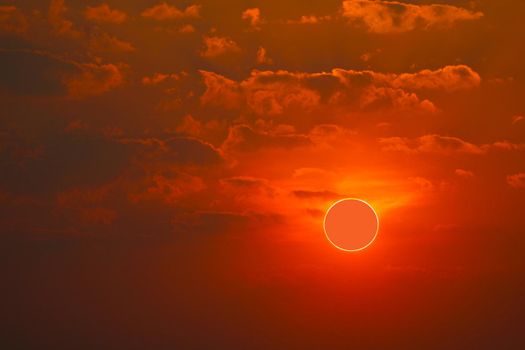 phenomenon of partial sun eclipse over sea and sunset sky