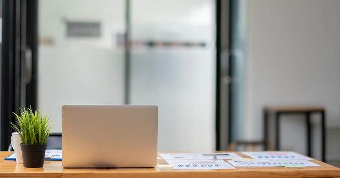 design of workplace with laptop and many financial report on wooden desk at home office