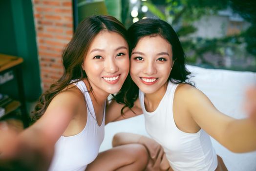 Happy young women friends sitting together