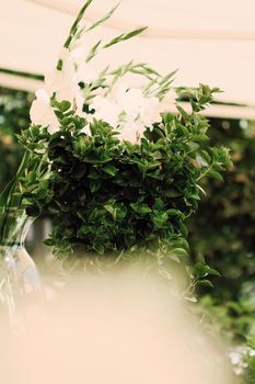 Floral wedding decoration in a restaurant outdoors in summer.