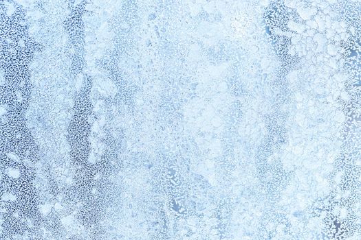 The texture of the glass covered with frost in winter in cold weather. Abstract natural background.