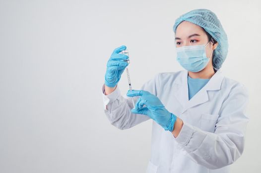 Asian doctor looking and preparing syringe vaccine and vial for injection to illness patient on white background. Medical people and illness prevention technology concept. Coronavirus epidemic theme