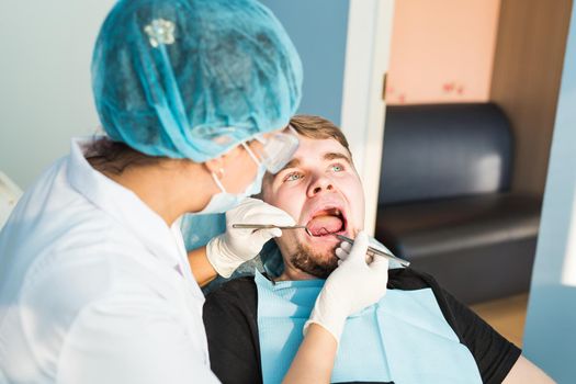 Woman dentist working at her patients teeth.