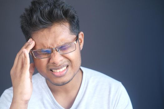 Young man frustrated and suffering headache, close up.