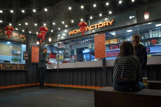 Interior of Asian Wok Factory Restaurant. People resting in hall. Chinese Fast Food concept. June 2020. Kyiv, Ukraine.