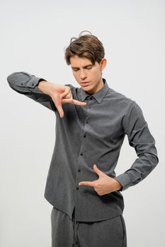 Holding a free space for your banner with hands free place for your text young man in grey shirt. Looking at hands man showing copy space for your product isolated on white background.