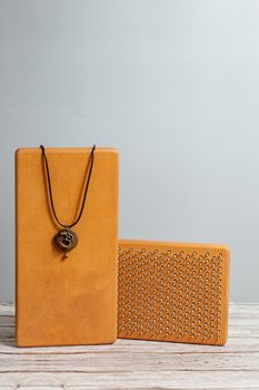Om Symbol Necklace. Brown Sadhu wooden boards with nails for yoga and spiritual practices on the grey background. The concept of meditation, standing on nails, therapy.