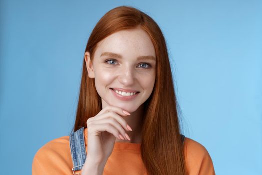 Curious smart creative young female redhead blue eyes have perfect idea how spend summer vacation smiling joyful look intrigued thoughtful touch chin pondering choice, standing blue background.