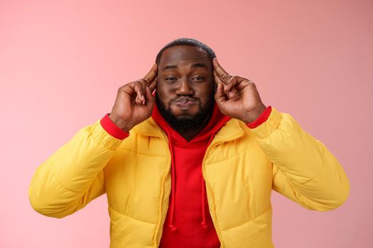 Mind blowing information. Portrait playful charismatic carefree african bearded young 25s man pouting hold breath childish having fun acting immature make funny grimace, standing pink background.