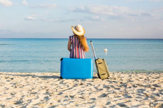 Freedom, travel, vacation and summer concept - Traveler woman with suitcases back view.