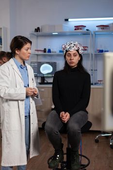 Neurologist doctor showing tomography expertise to woman patient with eeg scanner during neurology experiment in lab, Specialist doctor analyzing brain evolution monitoring nervous system activity