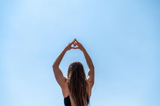 Young beautiful sportwoman practicing yoga. Coach teaching tree pose at the beach.