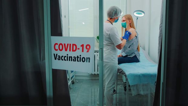 Female doctor making vaccination against the coronavirus in district hospital. Woman was vaccinated against Sars-Cov-2.