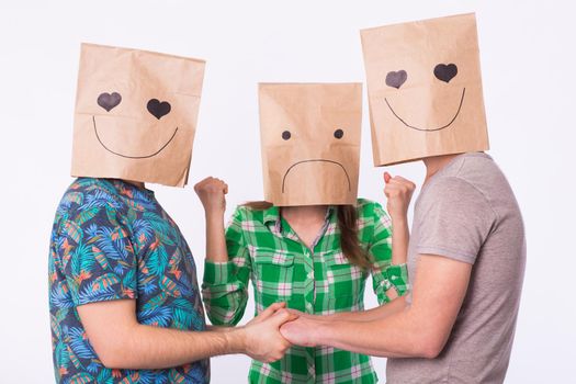 Love triangle, jealousy and homosexuality concept - gays with bags over heads holding hands and another woman is angry.