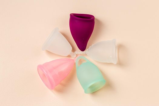 Five menstrual cups of different size, shapes and colors for sustainable and comfortable menstruation cycle periods. Reusable eco friendly hygiene products